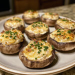 Champignons de Paris farcis au fromage frais, cuits au four et parsemés de ciboulette.