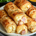 Cigares dorés en feuille de brick fourrés au jambon, pommes de terre et fromage, servis avec salade verte.