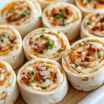 roulés apéritifs au cheddar, bacon et sauce ranch, bien découpés en tranches colorées et servies bien fraîches – parfaits pour un apéro convivial.