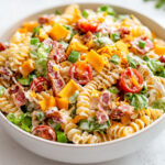 Salade de pâtes fraîche au ranch avec lardons, cheddar, tomates cerises et laitue croquante, idéale pour l’été.
